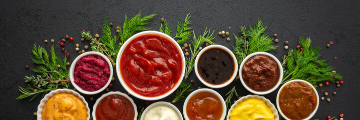 Different types of sauces in bowls with seasonings banner, rosemary and dill, thyme and and peppercorns, top view, copy space