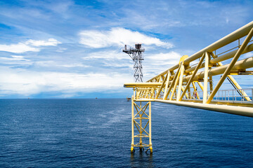 The bridge extends to release gas or a burning flame on an offshore platform.