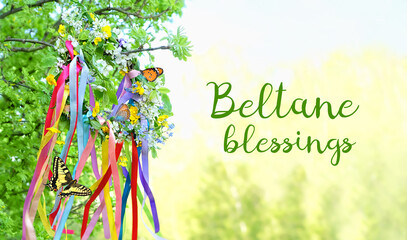 Beltane blessings. Floral wreath with colorful ribbons and butterflies on natural background....