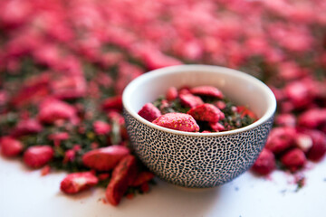 dehydrated strawberry-dried tea with mint and strawberries in mug or cup. dry herbal tea with peppermint, strawberry slices, dry strawberry halves