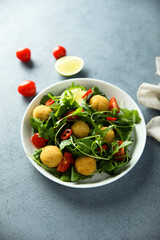 Healthy arugula salad with fish croquettes