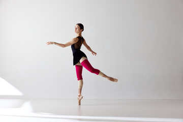 Young classical dancer dancing on fingertips over white background © Lustre Art Group 