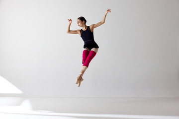 Shot of jumping ballerina with stretched feet over white background © Lustre Art Group 