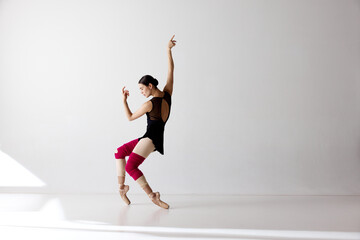 Photo of gorgeous ballerina wearing pointe shoes dancing on fingertips over white background © Lustre Art Group 