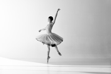 Monochrome. Ballerina wearing tutu in motion showing ballet elements while standing on pointe shoes...