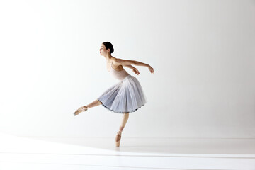 Ballerina dancing graceful movement in dress over white background. Beauty of classic ballet © Lustre Art Group 