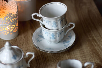 Vintage white tea set with pale blue flowers. Selective focus.