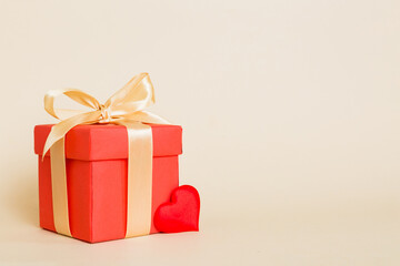 gift box with red bow and red heart on colored background. Perspective view. Flat lay