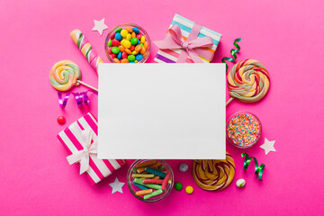 Fototapeta na wymiar Flat lay holiday composition. Paper blank, lollipop, birthday decorations on Colored background. Top view, copy space for text