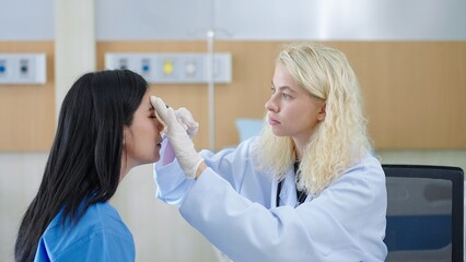 Professional caucasian woman plastic surgeon making injecting in asian woman patient face for plastic surgery at the clinic