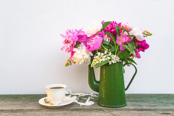 Greeting card with bouquet of pink peonies in vintage coffee pot and white retro cup of coffee on white background