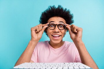 Photo of youngster geek student guy addicted professional programmer touch his computer glasses before coding isolated on aquamarine color background