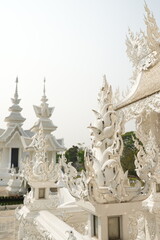"Wat Rong Khun" Famous temple in chiangrai Thailand. Beautiful white temple with green field for travel landmark
