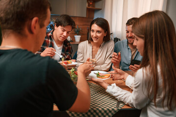 Delicious food. Group of people are on the kitchen, having dinner, spending time together