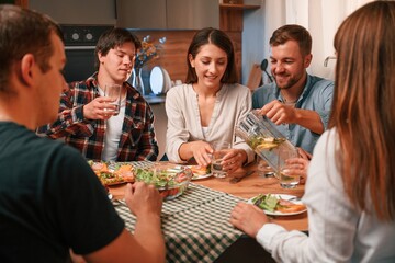 Delicious food. Group of people are on the kitchen, having dinner, spending time together