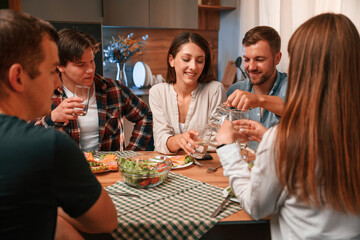 Group of people are on the kitchen, having dinner, spending time together