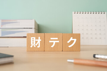 財テクと書かれたブロックが置かれたデスク