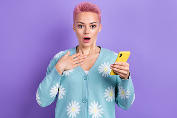 Photo of impressed astonished woman with short hairstyle dressed blue cardigan hold smartphone hand on chest isolated on purple color background - obrazy, fototapety, plakaty