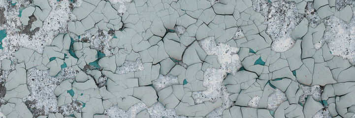 Peeling paint on the wall. Panorama of a concrete wall with old cracked flaking paint. Weathered...