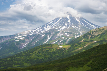 Fototapeta premium View of the volcano. Travel and tourism on the Kamchatka Peninsula. Beautiful nature of Siberia and the Russian Far East. Vilyuchinsky Volcano (Vilyuchinskaya Sopka), Kamchatka Territory, Russia.
