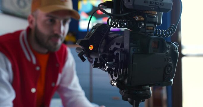 Filmmaker holding a focus wheel and testing the wireless follow focus system on a Canon camera