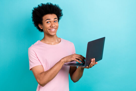 Photo of positive funny smiling young programmer it developer studying code python typing computer isolated on aquamarine color background