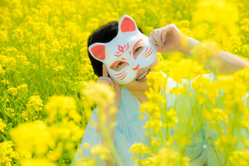 Japanese woman in a beautiful yellow flowers field