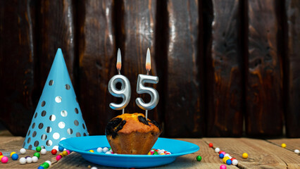 Beautiful anniversary background happy birthday with a cupcake and a burning candle. Happy birthday anniversary on wooden background with decorations with number 95