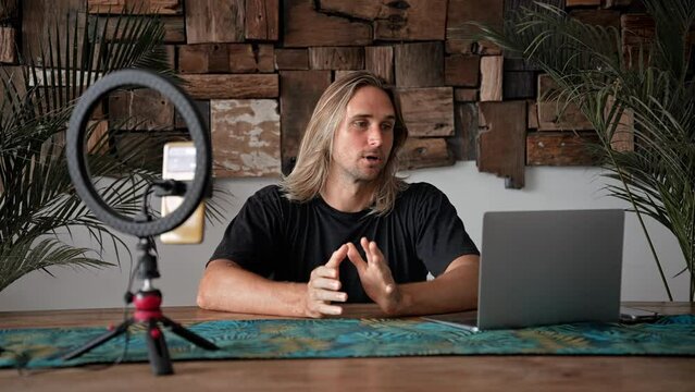 Influencer guy record video blog. Blogger use mobile cell phone. Vlogger shoot online live vlog. Speaker talk stream broadcast. Educational zoom webinar. Web cam home studio job. Teaching work call.
