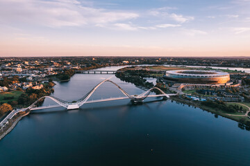 Panoramic aerial view at sunrise of Matagarup Bridge across the Swan River in the city of Perth,...