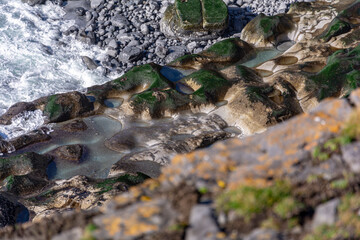 Wet stones on an Irish beach with white waves