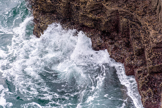 White waves on a blue Irish rocky cliff in a blue sky dasy