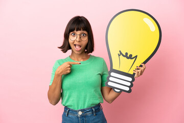 Youing woman holding a bulb icon and pointing it
