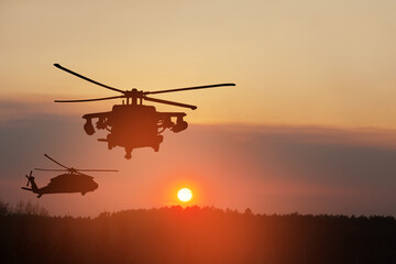 Fototapeta na wymiar Silhouettes of helicopters on background of sunset.