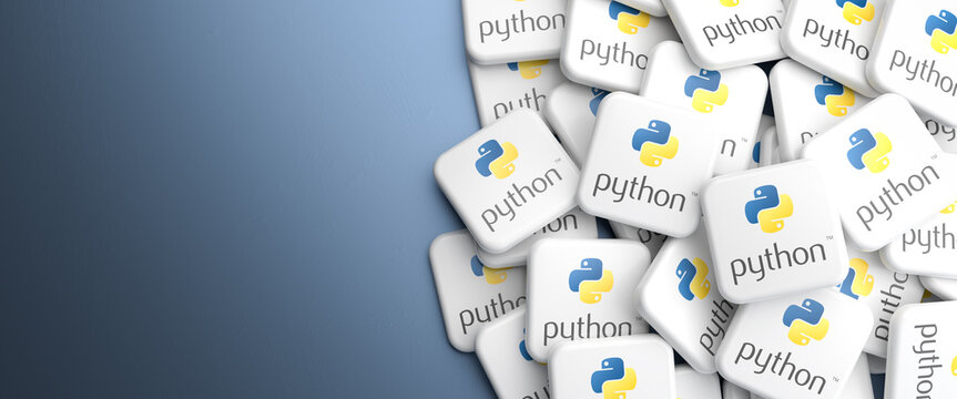 Logos of the programming language Python on a heap on a table. Web banner format, copy space