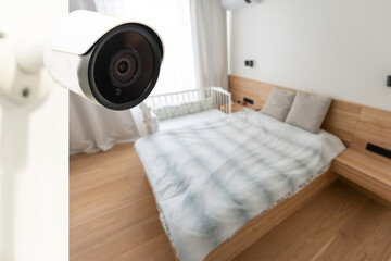 Close Up Object Shot of a Modern Wi-Fi Surveillance Camera with Two Antennas on a White Wall in a Cozy Apartment Has Wi-Fi Icon Above it.