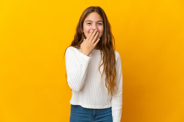 Child over isolated yellow background happy and smiling covering mouth with hand