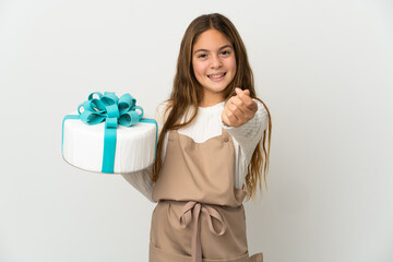 Little girl holding a big cake over isolated white background making money gesture