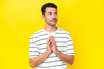 Young handsome man over isolated yellow background scheming something