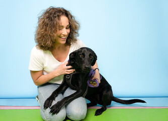 Happy woman with a beautiful dog - isolated over blue background
