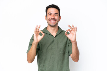 Young handsome man over isolated white background showing ok sign with two hands