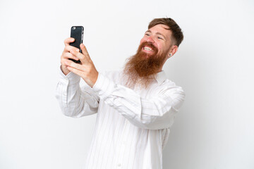 Redhead man with long beard isolated on white background making a selfie