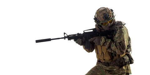 Mercenary soldier with an automatic rifle in his hand looking back.