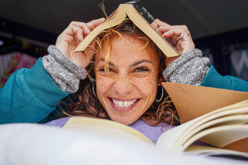 happy woman with a book on the head looking at camera. World book day. Sant jordi day.