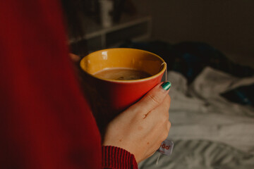 warming hands in a tea mug