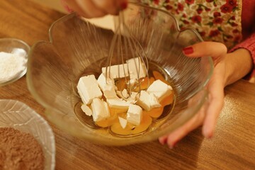 Close-up shot of mixing ingredients for making cakes, cookies or pastries. Detail images of beating butter, flour and eggs for dough making.