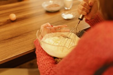 Close-up shot of mixing ingredients for making cakes, cookies or pastries. Detail images of beating butter, flour and eggs for dough making.