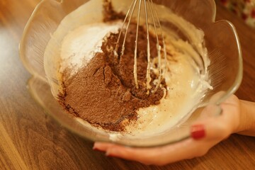 Close-up shot of mixing ingredients for making cakes, cookies or pastries. Detail images of beating butter, flour and eggs for dough making.