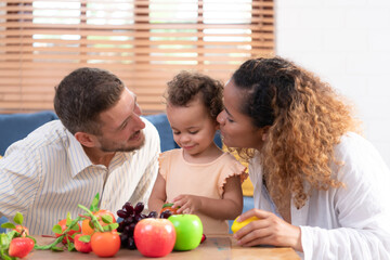 Parents and children relax in the living room of the house. Watch baby happily play with his favorite toy.