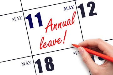 Hand writing the text ANNUAL LEAVE and drawing the sun on the calendar date May 11